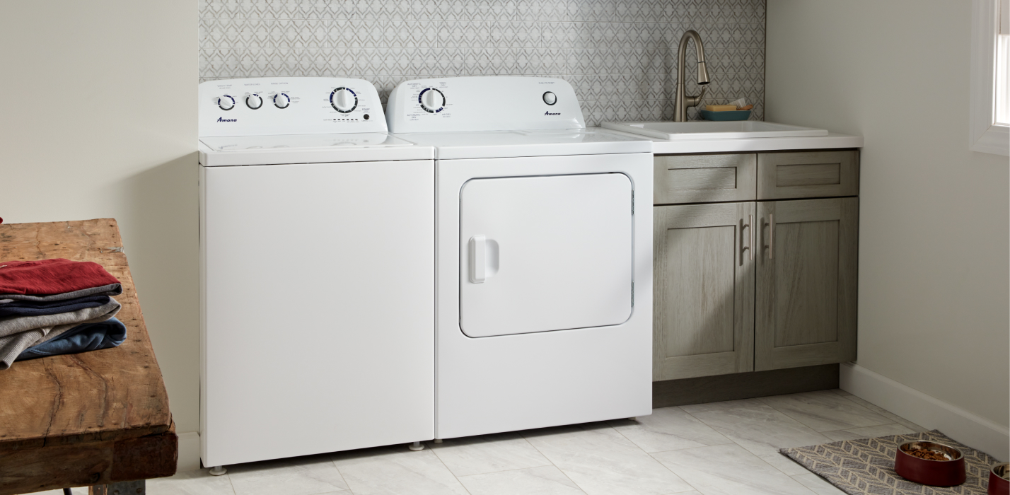 A white Amana® top load washer and dryer in a laundry room