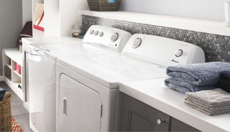 Side view of a white Amana® top load washer and dryer in a laundry room