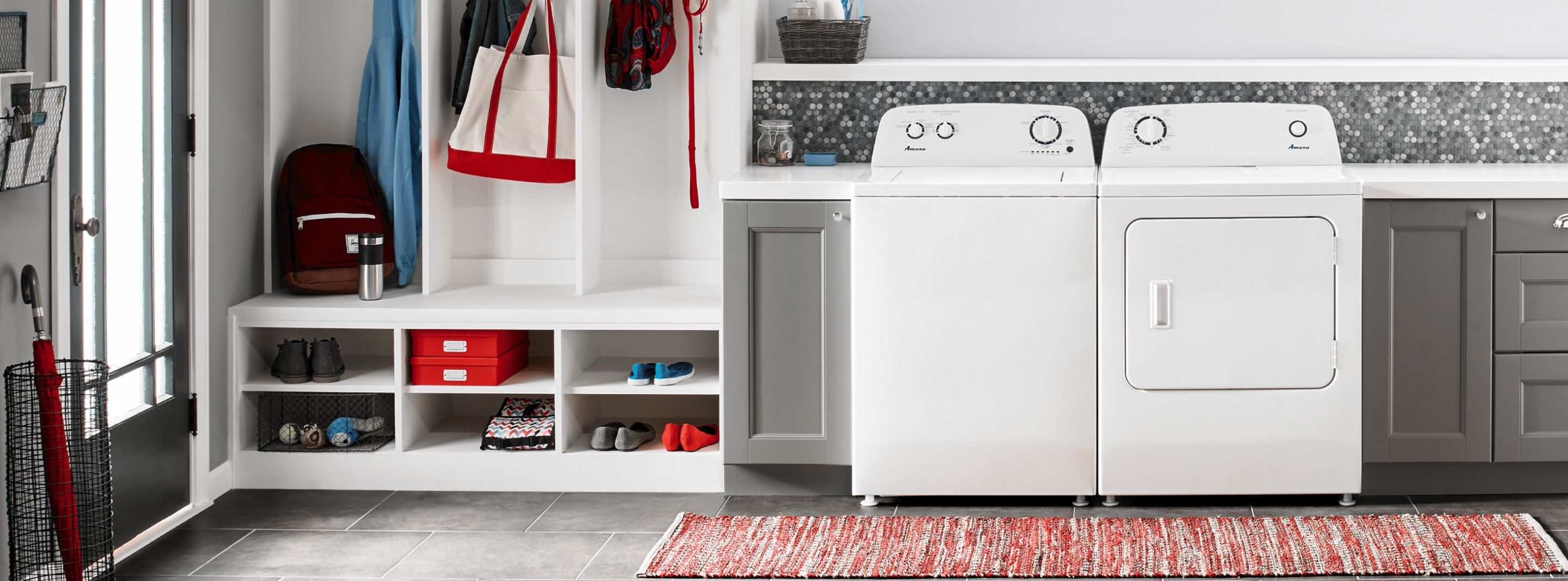 A white Amana® washer and dryer in grey cabinetry