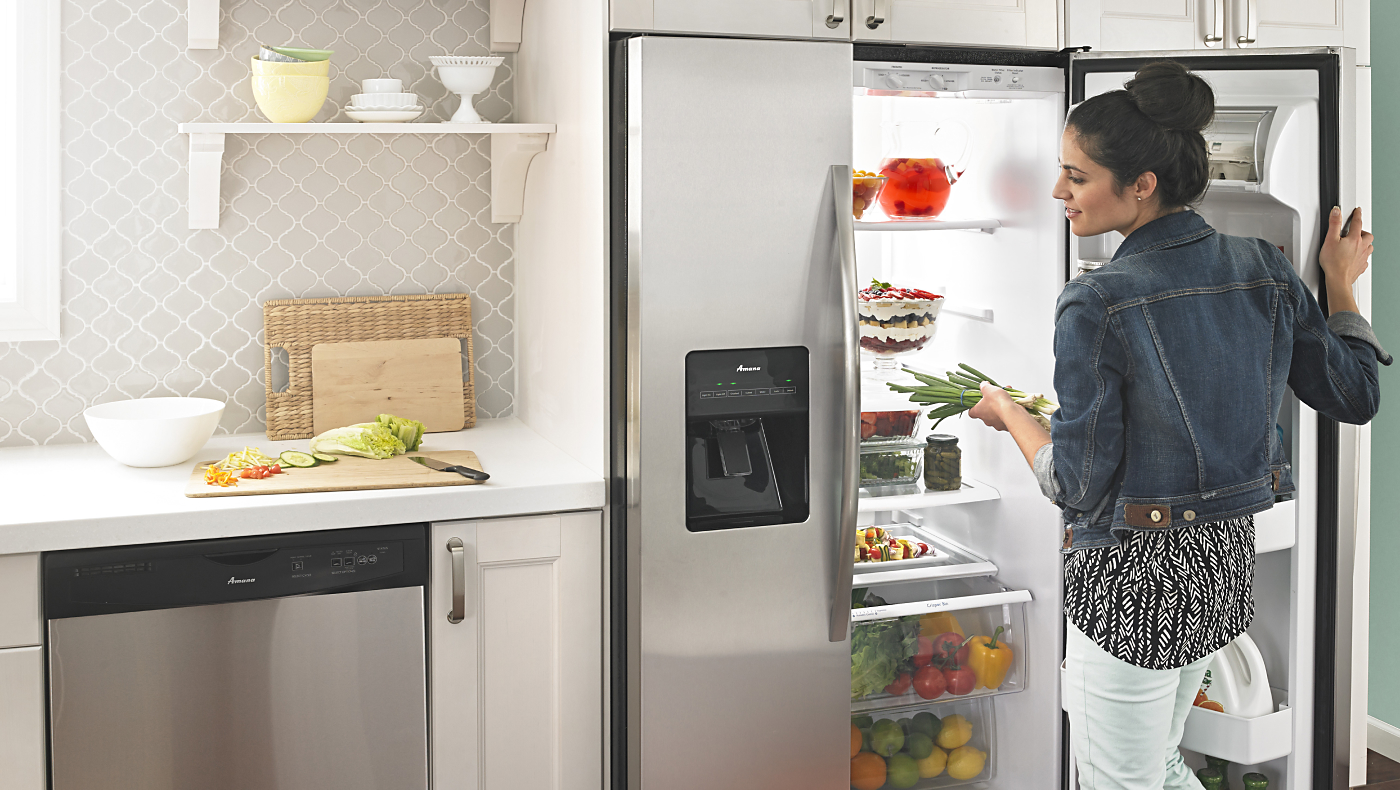  Person getting food out of Amana® refrigerator