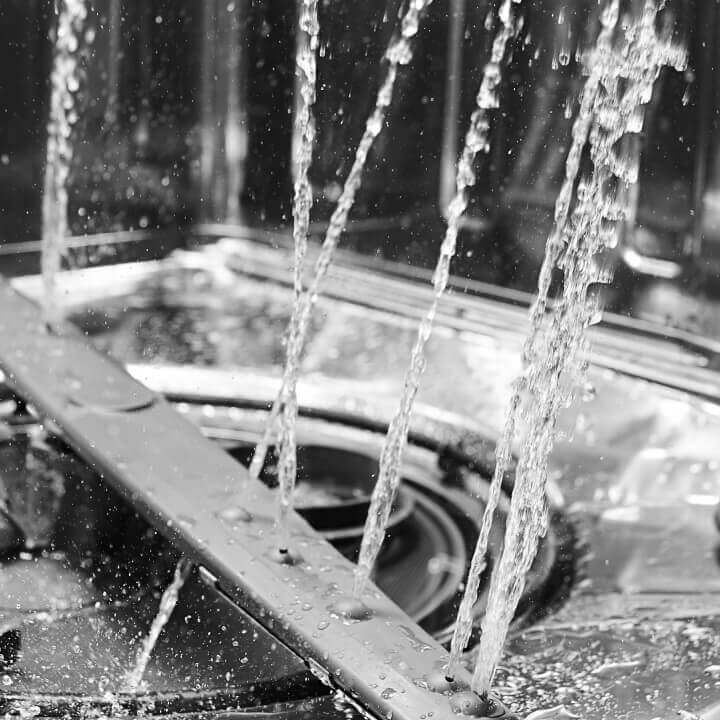 Close up on water spraying inside a dishwasher Close up on water spraying inside a dishwasher
