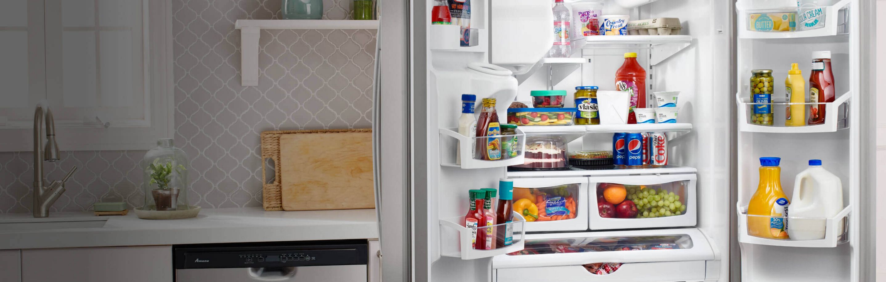 Open Amana® refrigerator with food inside