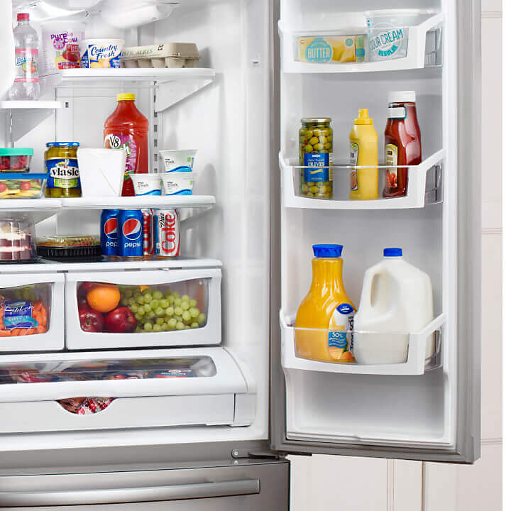 Open Amana® refrigerator with food inside