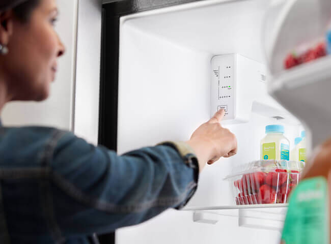 Person adjusting refrigerator temperature