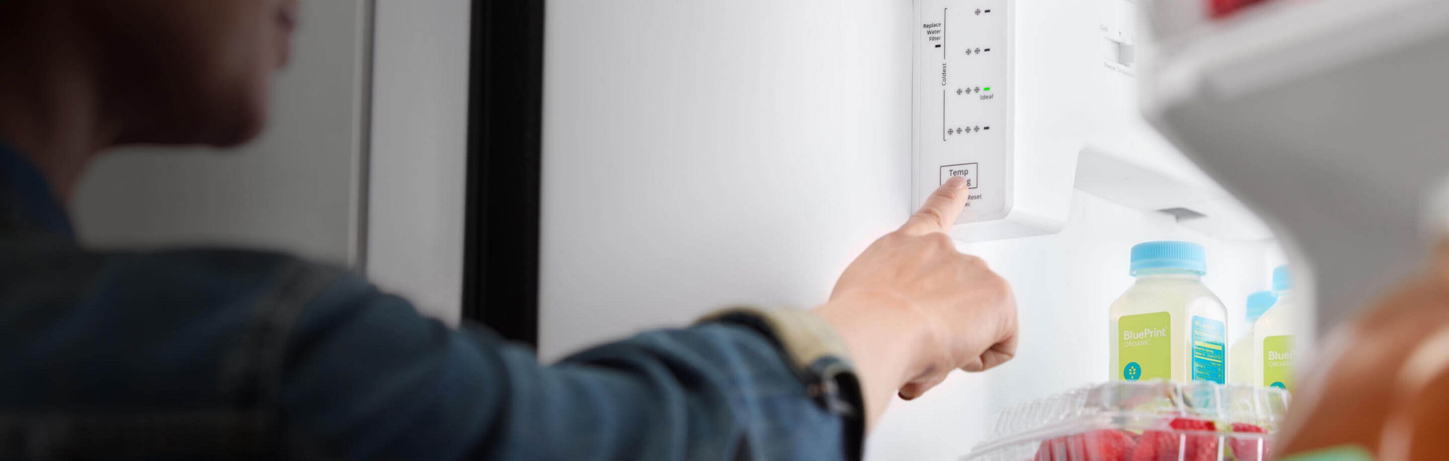 Person adjusting refrigerator temperature