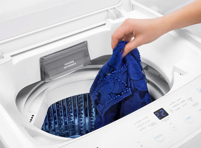 Person putting clothes into washer