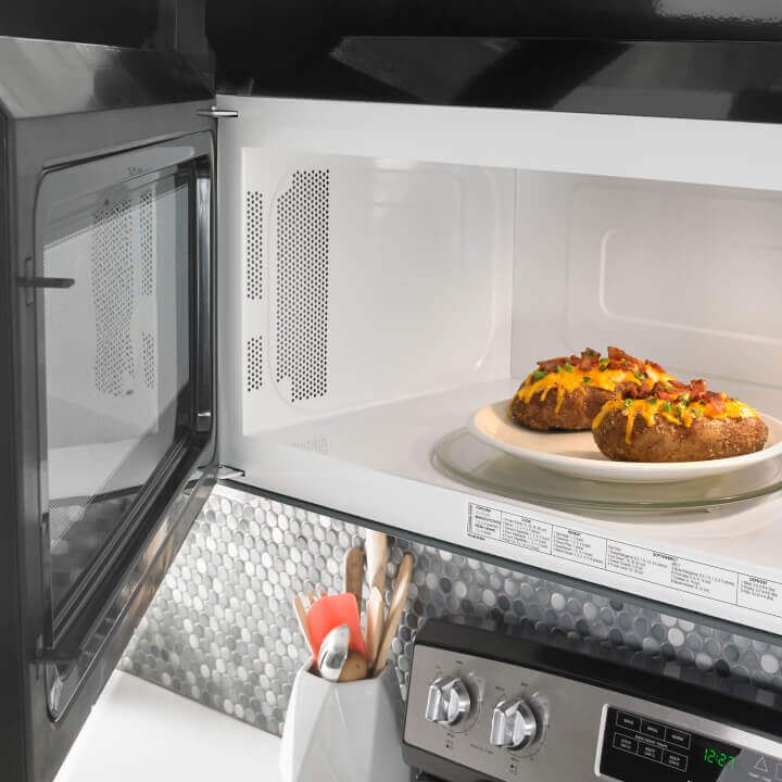 Amana® microwave with door open and food inside
