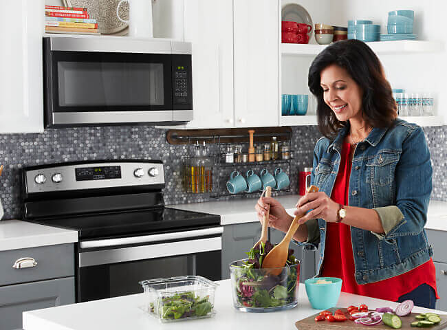 Person prepping food in a kitchen with Amana® kitchen appliances