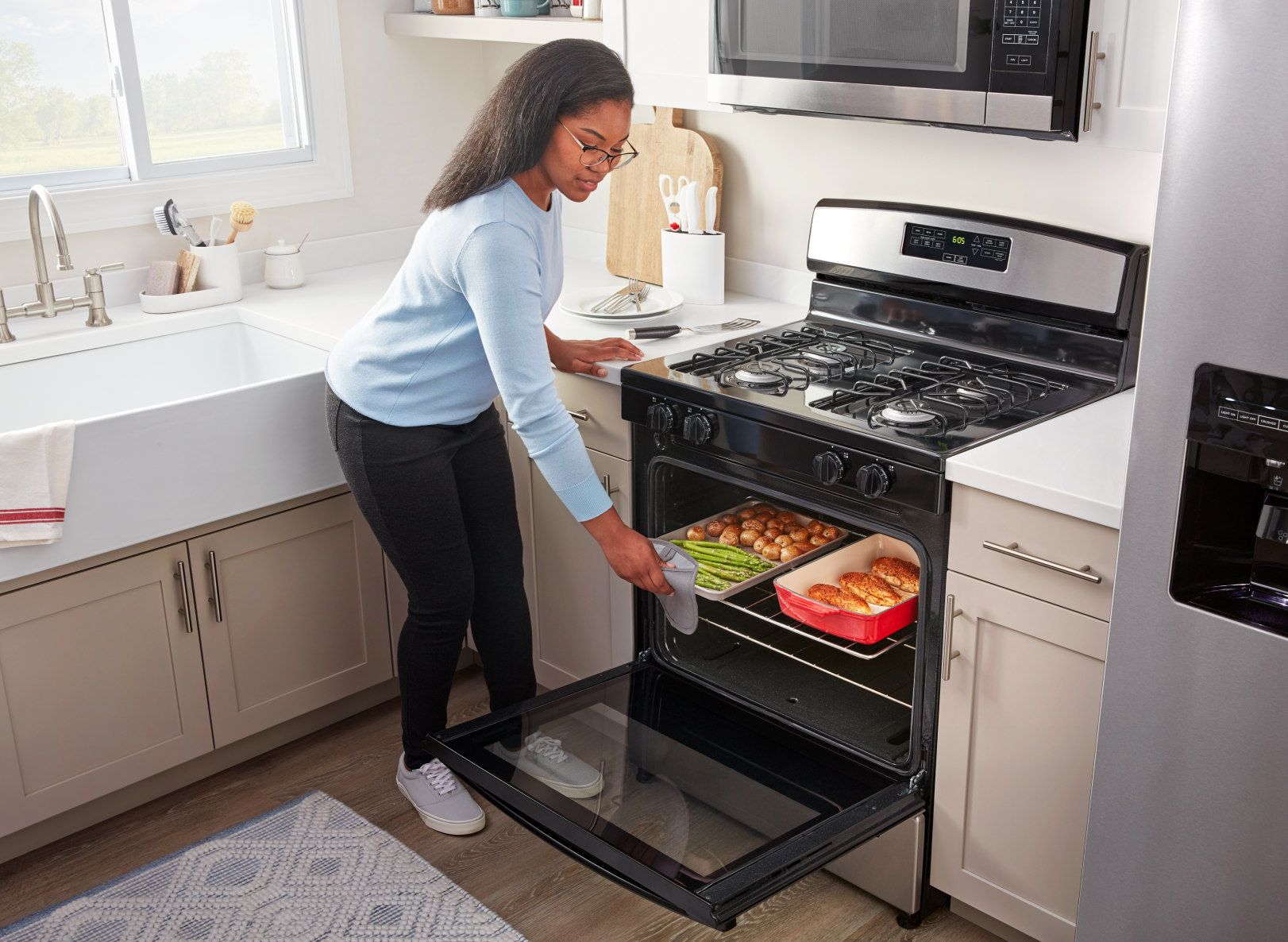 Person loading pans of food into an Amana brand oven
