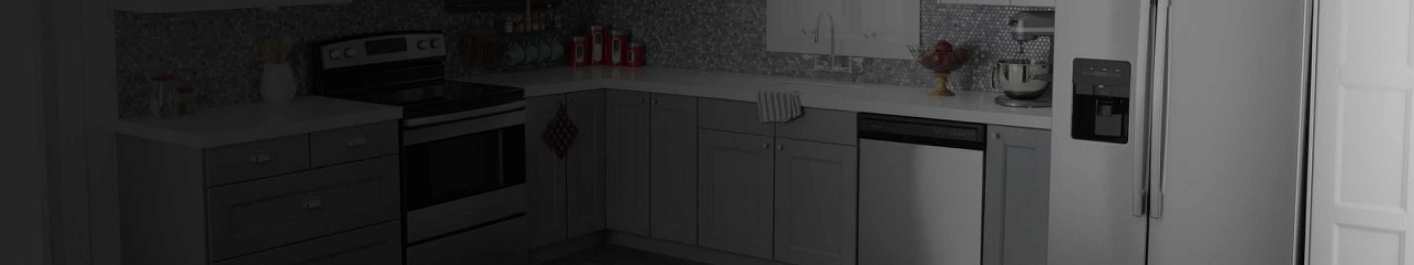 A kitchen with stainless steel appliances and gray cabinets.
