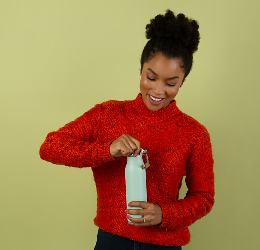 A woman opening a mint-colored water bottle.