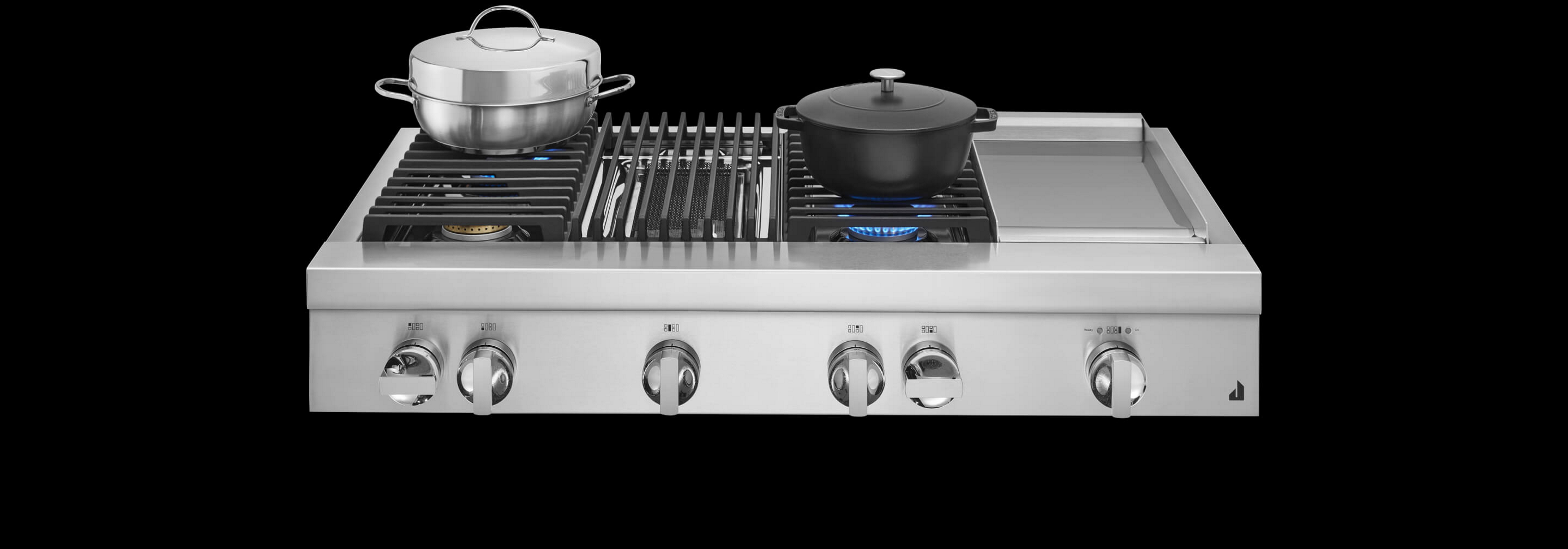 A JennAir® Professional-Style Range in NOIR™ Design, with stainless steel and cast iron pans atop lit burners.