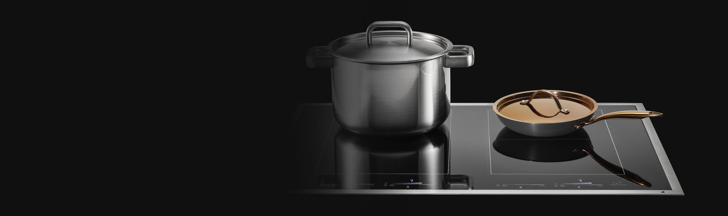 A stockpot and copper pan on a JennAir Induction Cooktop. 