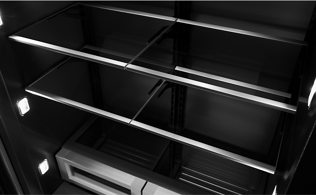 A shot of the glass shelves and  Daring Obsidian Interior of a JennAir Refrigerator. 