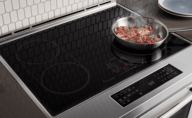 Fresh ingredients being cooked on an induction cooktop on a range.