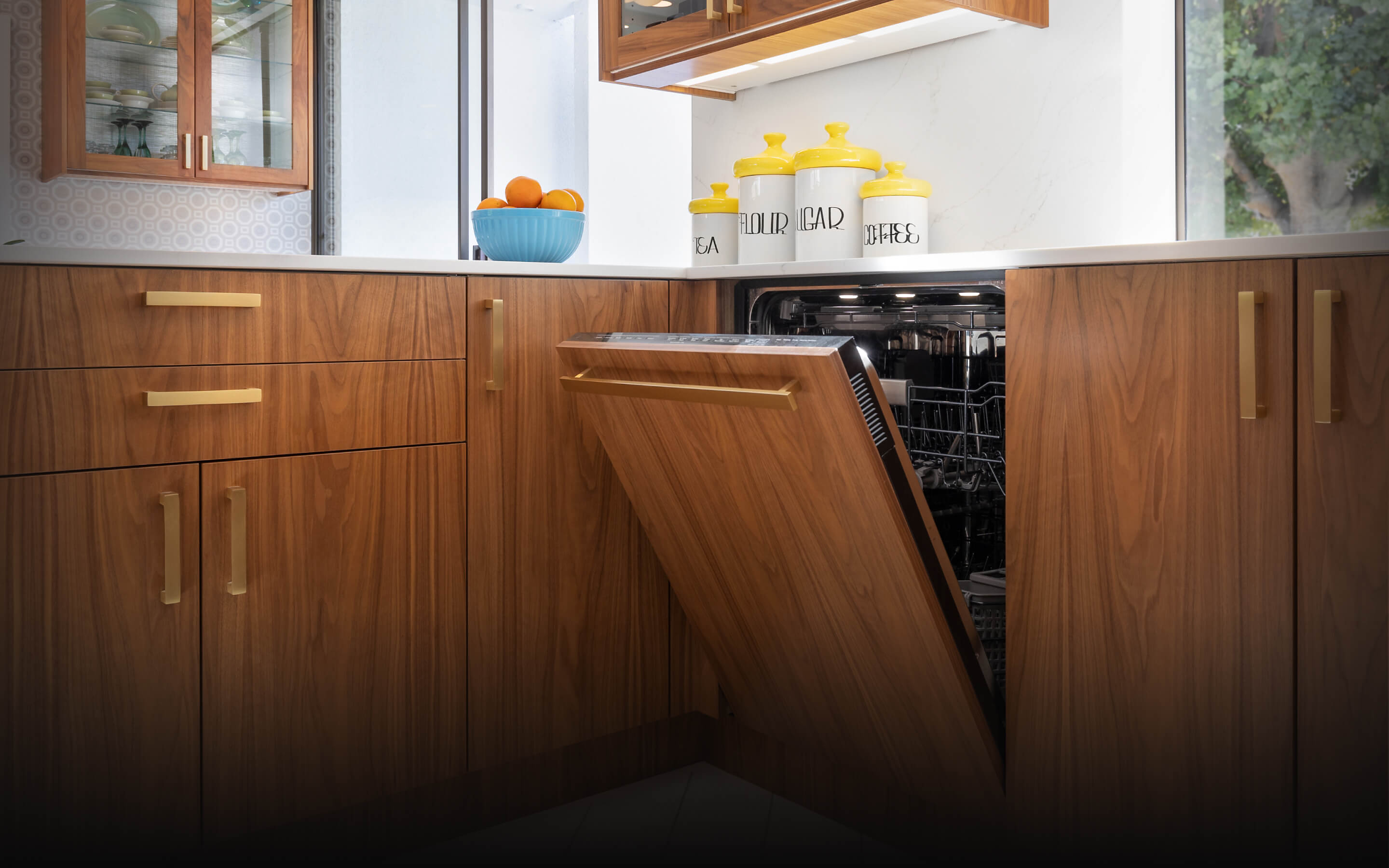 A JennAir® Panel-Ready Dishwasher in a kitchen with retro wooden cabinets.