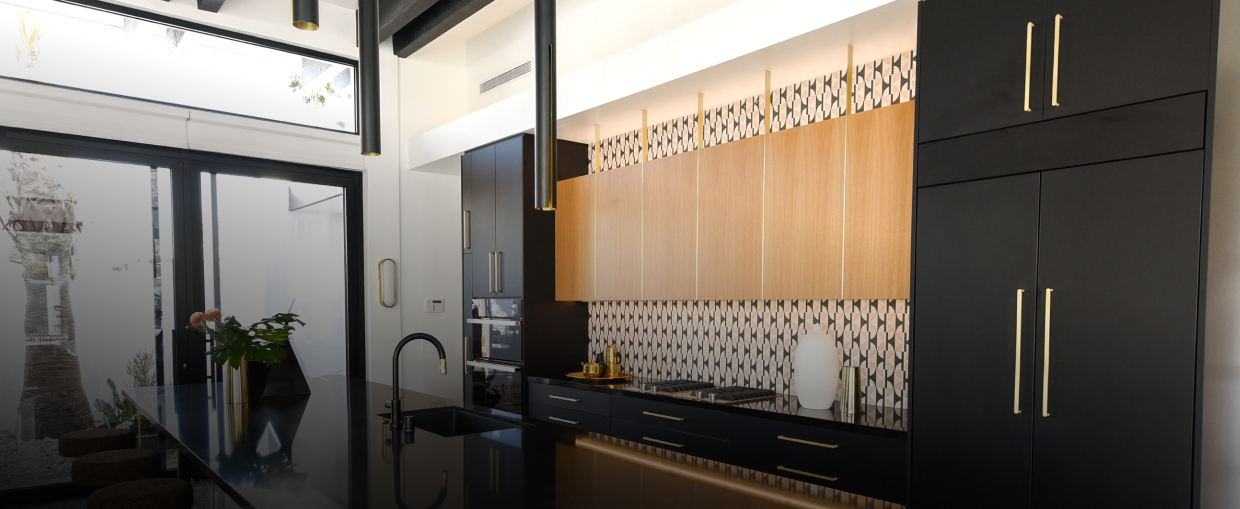 A modern kitchen filled with built-in refrigerators fitted with custom panels.