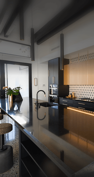 A black and gold modern kitchen featuring JennAir® appliances.