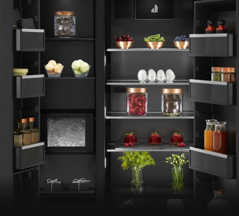 The interior of a built-in refrigerator filled with vibrant foods and ingredients.