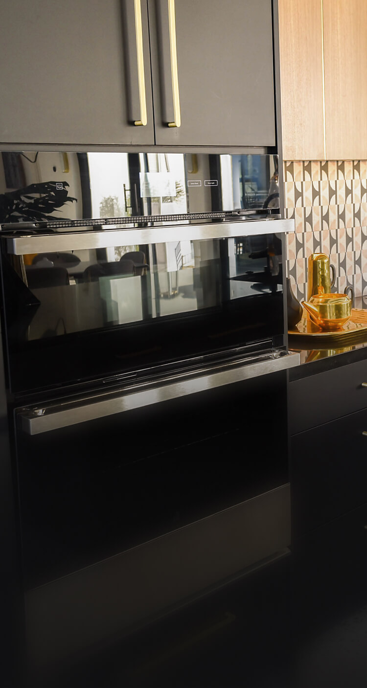A JennAir® NOIR™ Microwave Combination Wall Oven in a modern kitchen with black cabinets.