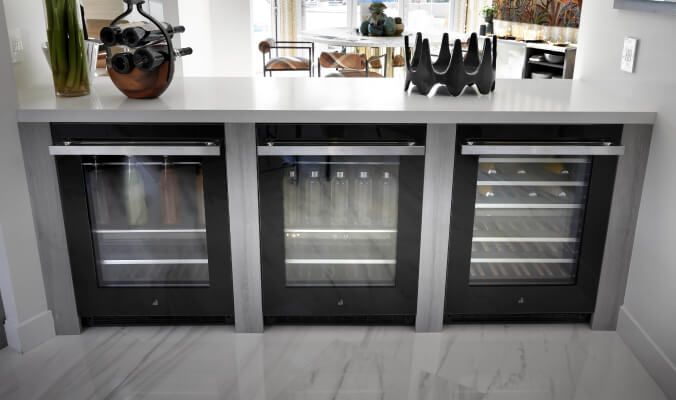 JennAir® undercounter beverage centers and wine cellars installed in a kitchen island.