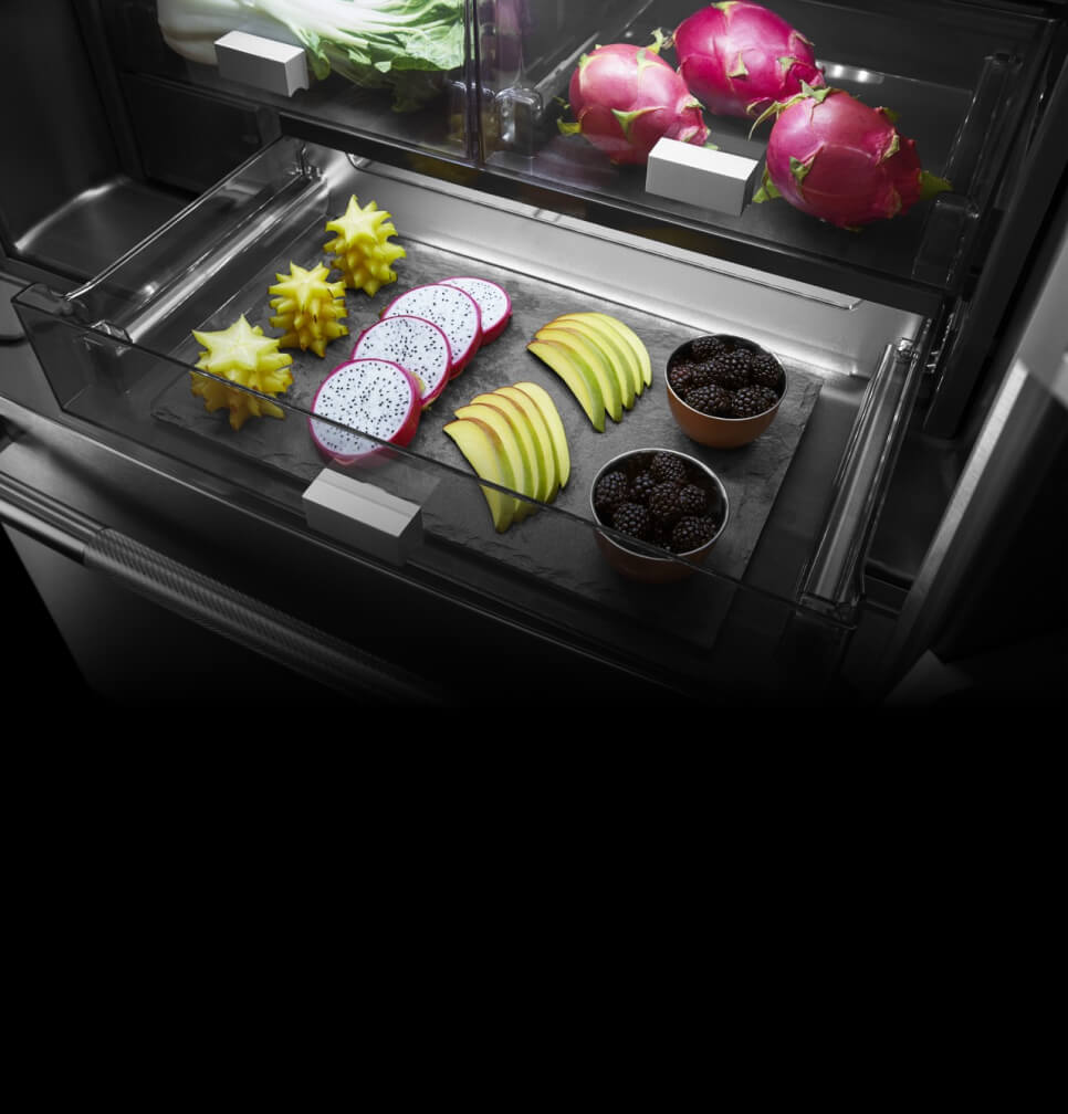 Bright light shining on colorful food inside a refrigerator drawer