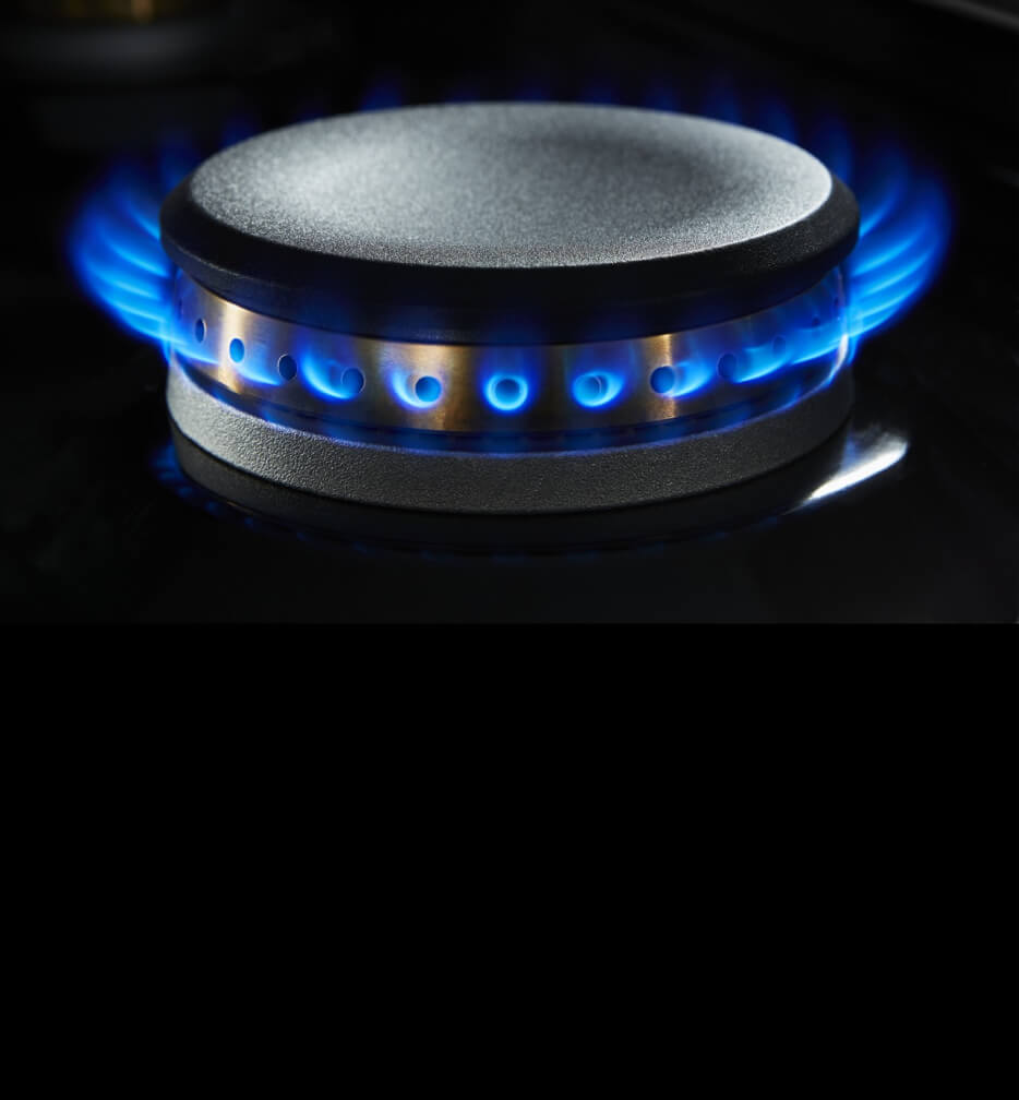 A lit dual-stacked burner on a gas rangetop.
