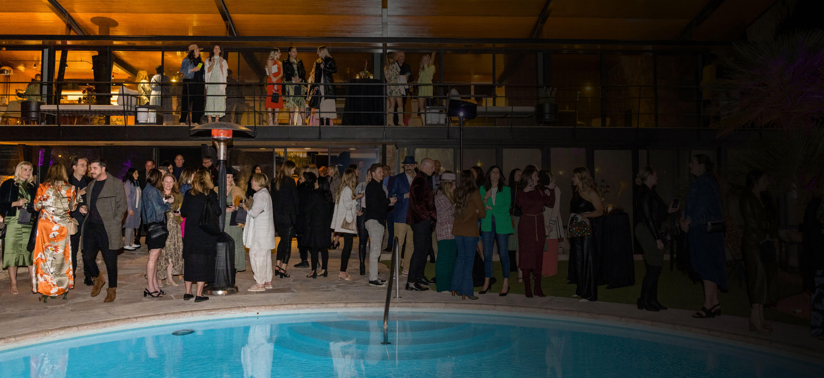 A large group of designers gathered around a pool at an exclusive JennAir event.