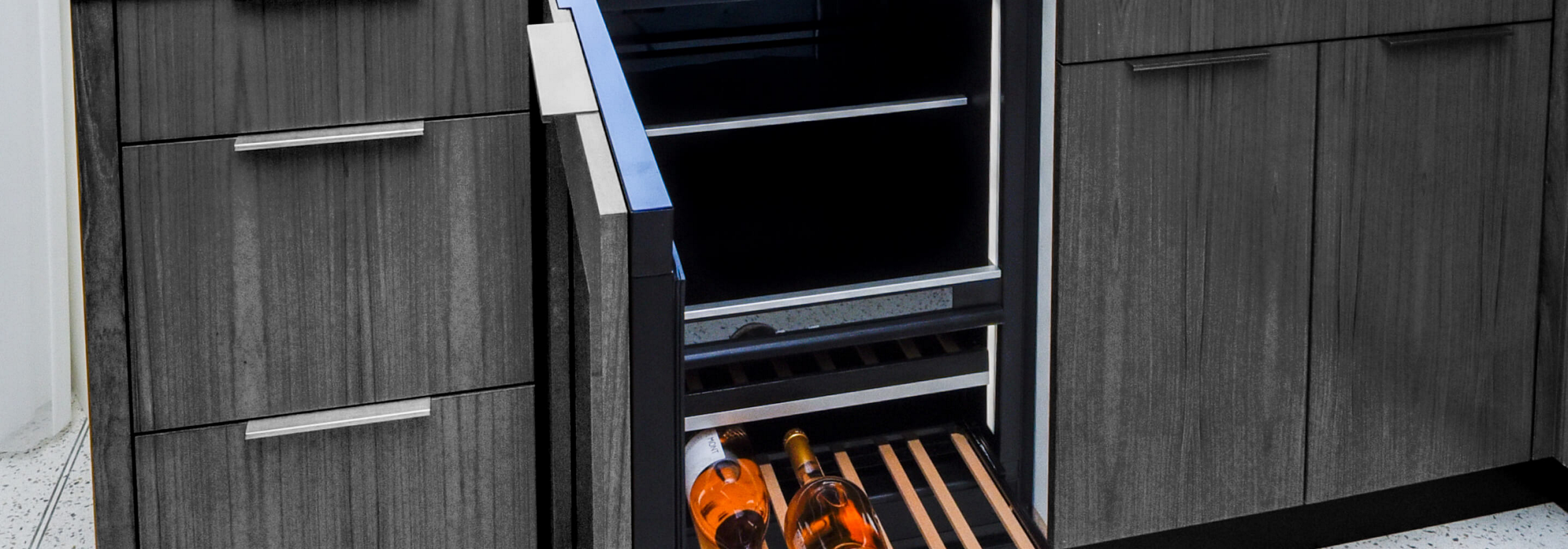An undercounter refrigerator equipped with custom wooden panels that match the surrounding cabinetry.