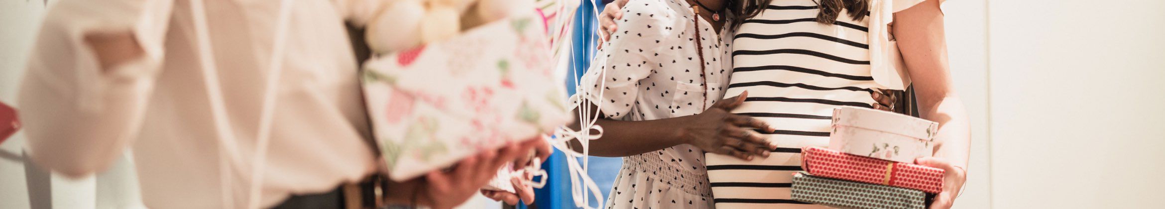People holding wrapped gifts. Two people are hugging
