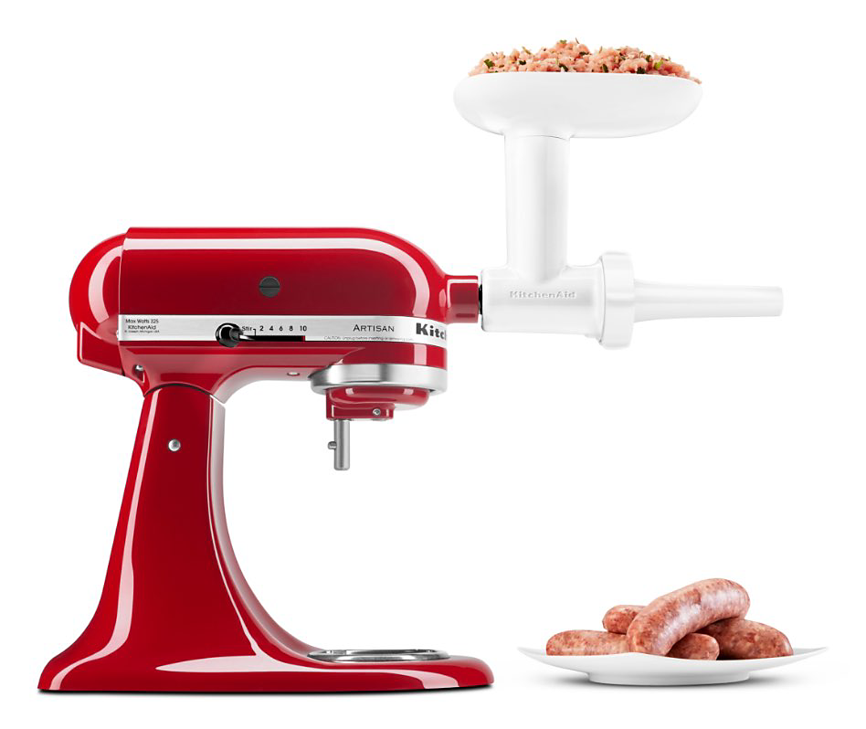 A KitchenAid Stand Mixer with a Food Grinder Attachment. Next to it is a plate of sausages