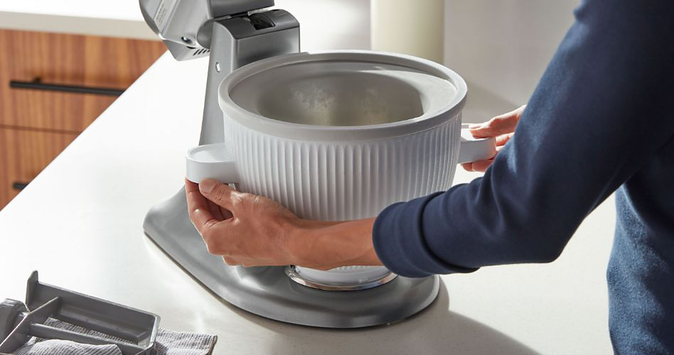 Un homme prépare un batteur sur socle KitchenAid pour faire de la crème glacée.