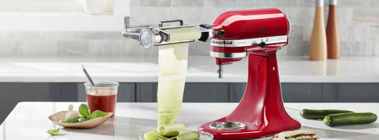 A red KitchenAid stand mixer with vegetable sheet cutter attachment is used to make zucchini sheets