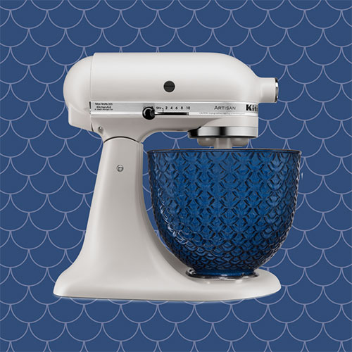 Milkshake colour Stand Mixer in front of blue textured background