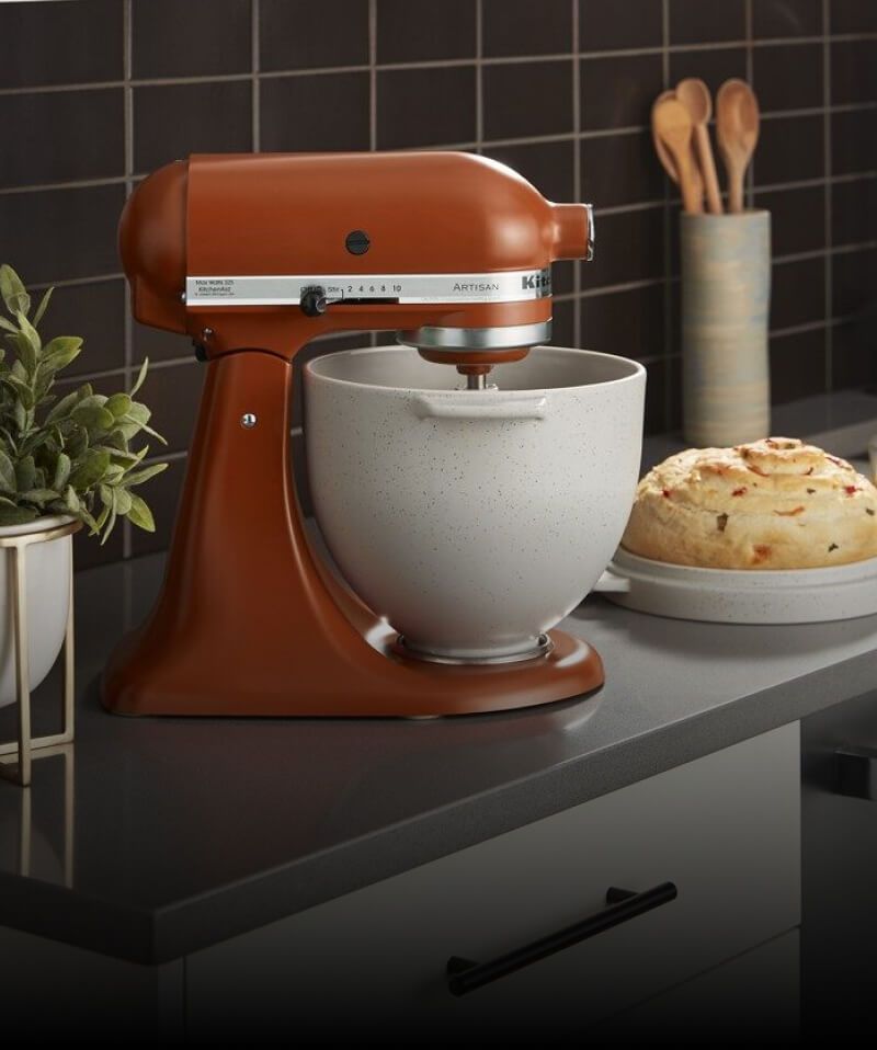 A KitchenAid® Tilt Head Stand Mixer in Scorched Orange on a countertop.
