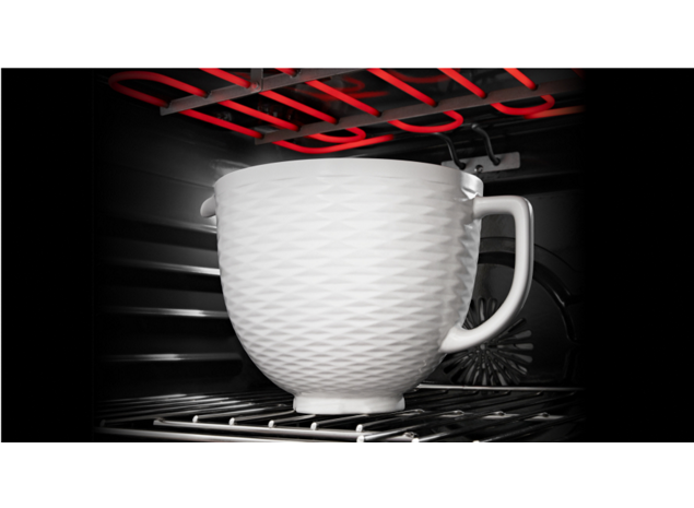 A KitchenAid® ceramic bowl placed in an oven.