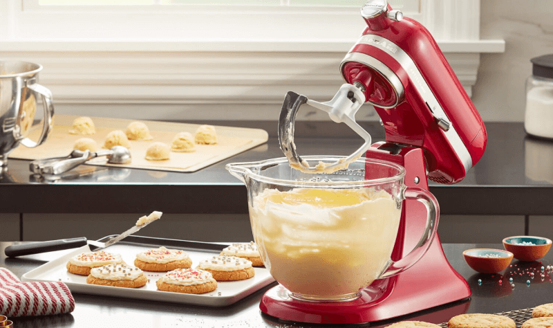 A red KitchenAid® stand mixer with a glass bowl.