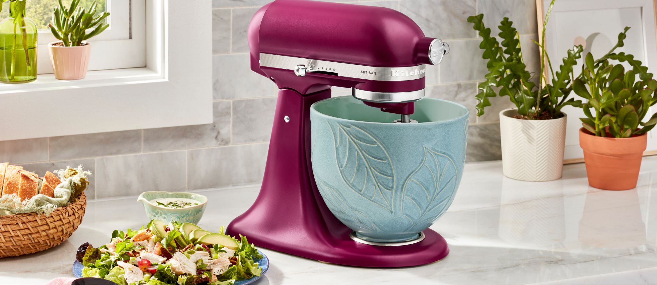 A KitchenAid® Stand Mixer in Beetroot with a 5 Quart Spring Leaves  Ceramic Bowl.
