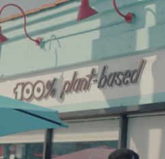 A restaurant exterior reading '100% plant-based.'