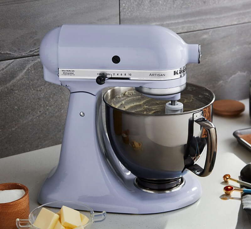 A KitchenAid® Stand Mixer on a countertop with a 5-quart stainless steel bowl beating butter. 