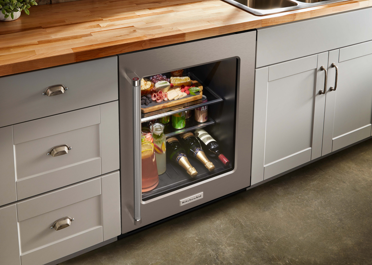 A KitchenAid® undercounter refrigerator among grey cabinets 
