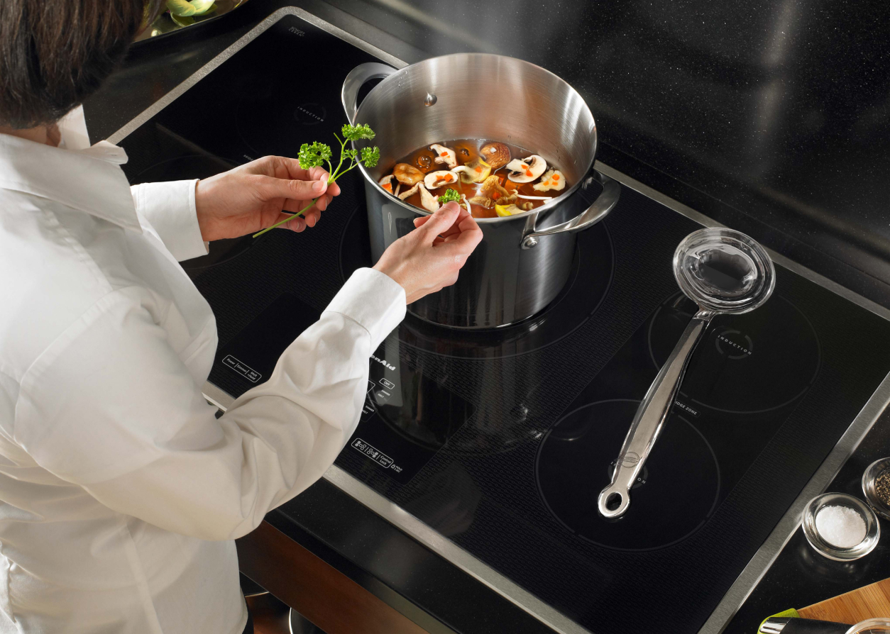 Woman cooking on an induction cooktop.