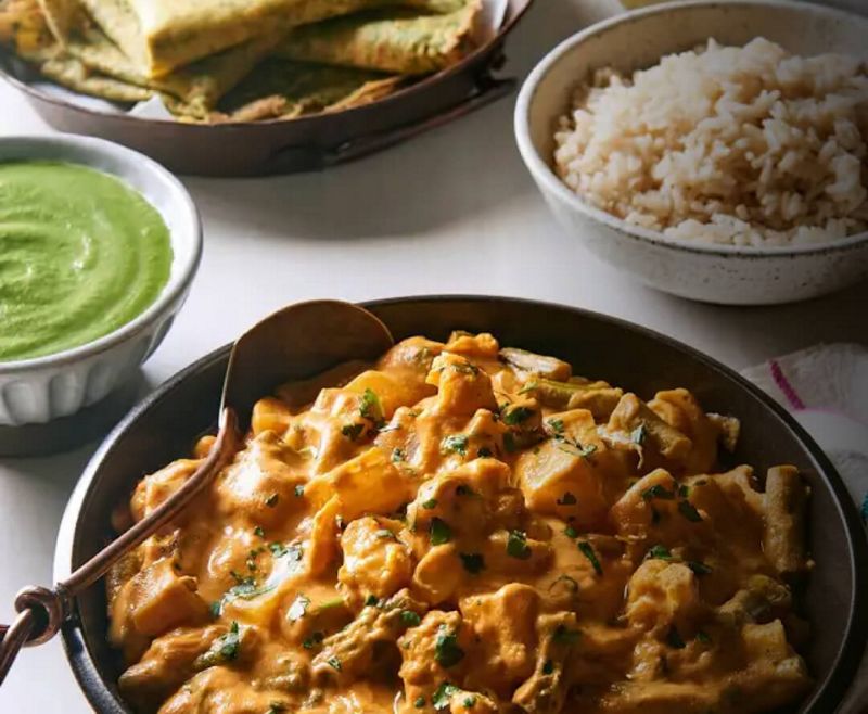 Bowl of creamy soup, a bowl of pesto, and pita bread.
