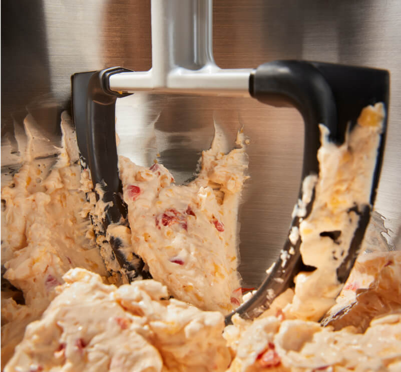 The interior of a KitchenAid® bowl-lift stand mixer mixing up dough. 