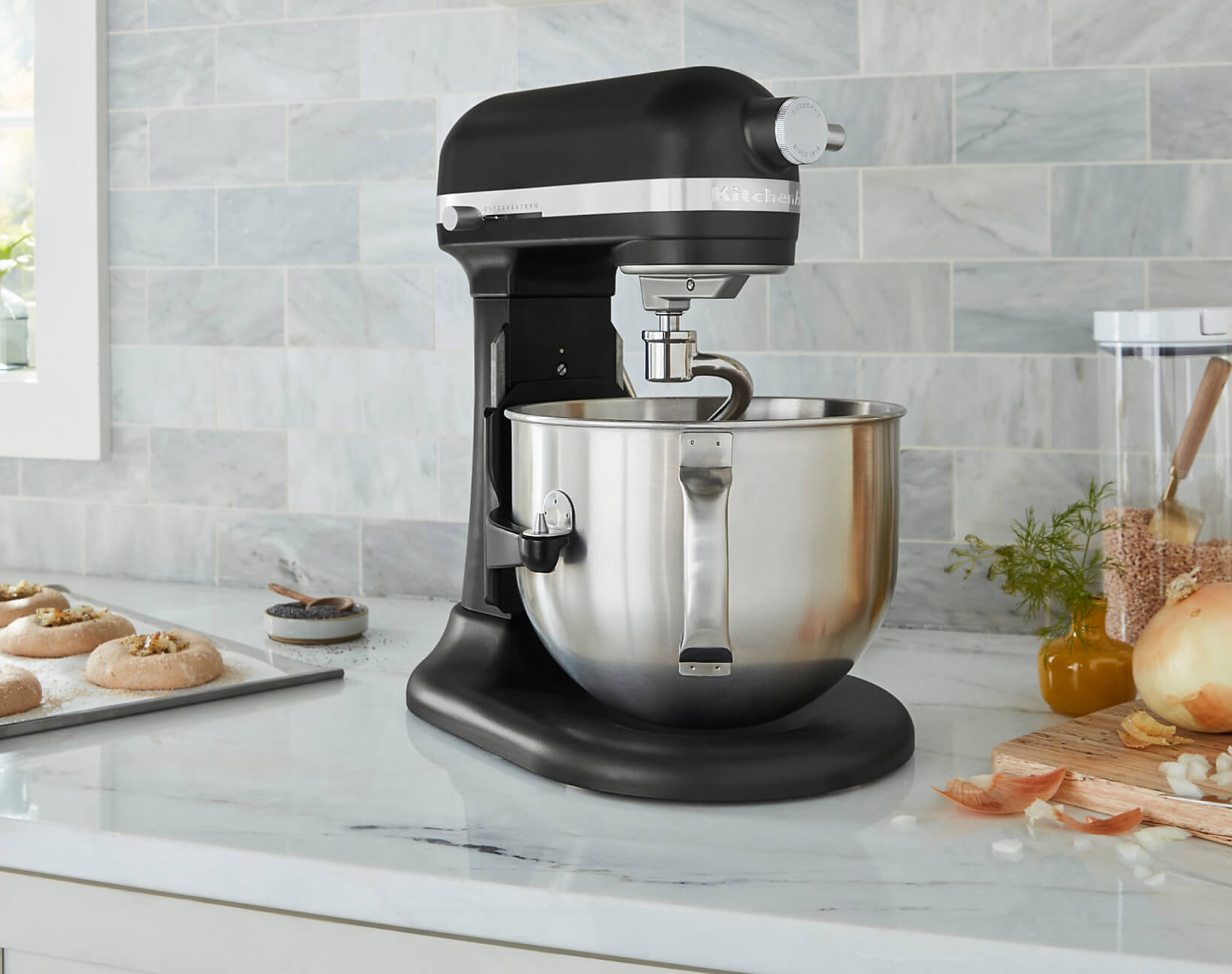A KitchenAid® bowl-lift stand mixer on a countertop surrounded by different ingredients. 