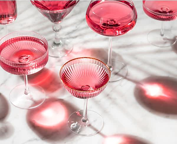 Un assortiment de cocktails remplis d'une boisson rose.