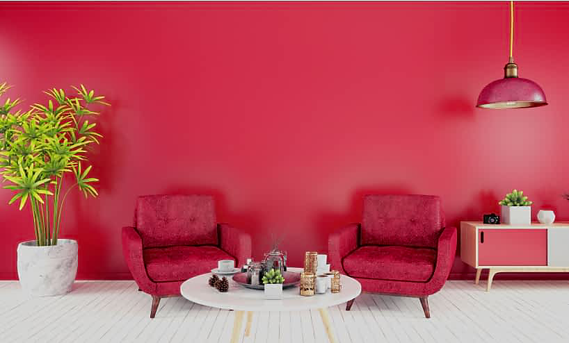 A bright fuchsia sitting room, with bold pink furniture and white accents.