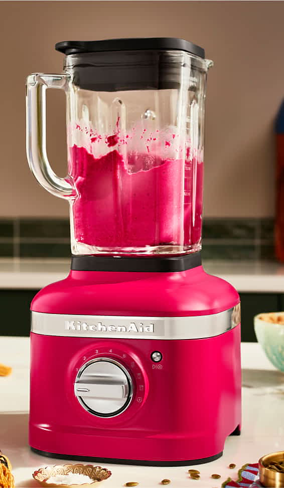 Un mélangeur à vitesse variable K400 de couleur Hibiscus, mélangeant un liquide rose.
