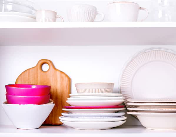 Vaisselle et bols blancs, bleu clair et hibiscus  sur une étagère.