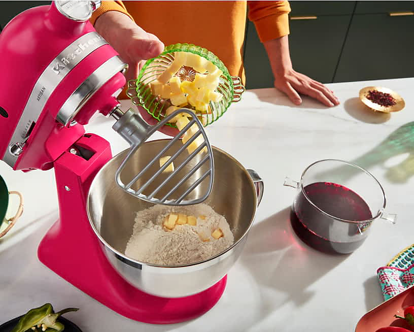 An Artisan® Stand Mixer in Hibiscus mixing flour and butter together with hibiscus tea prepared next to the mixer.